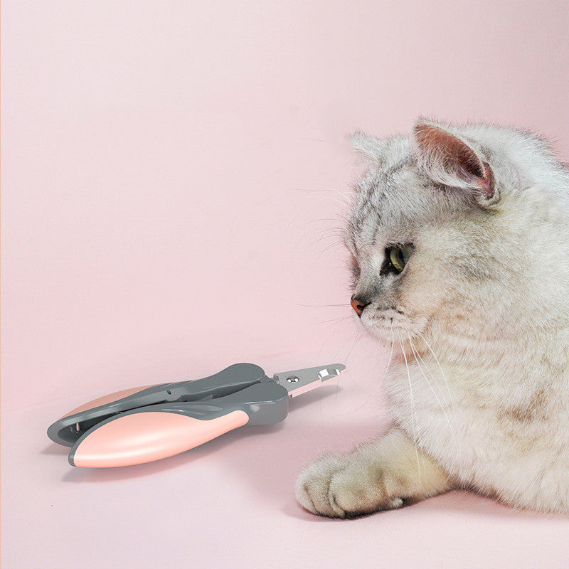 Pawssiblypets dog nail clippers with ergonomic handle placed next to a curious gray and white cat