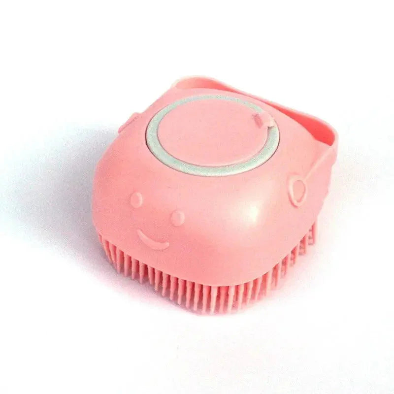 Pink handheld silicone dog bath brush with a smiley face on a white background