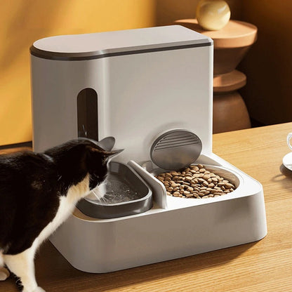 Pawssiblypets automatic cat feeder with water and food bowls on wooden table with cat drinking water