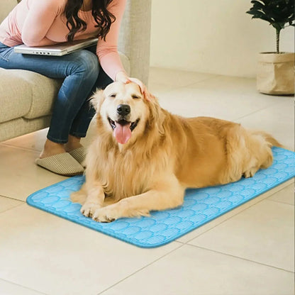Golden retriever lying on a blue dog cooling mat while a person pets its head indoors