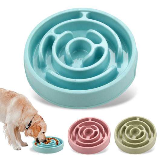 Teal slow feeder bowl for pets with a dog eating from it, and additional pink and green bowls in the foreground.